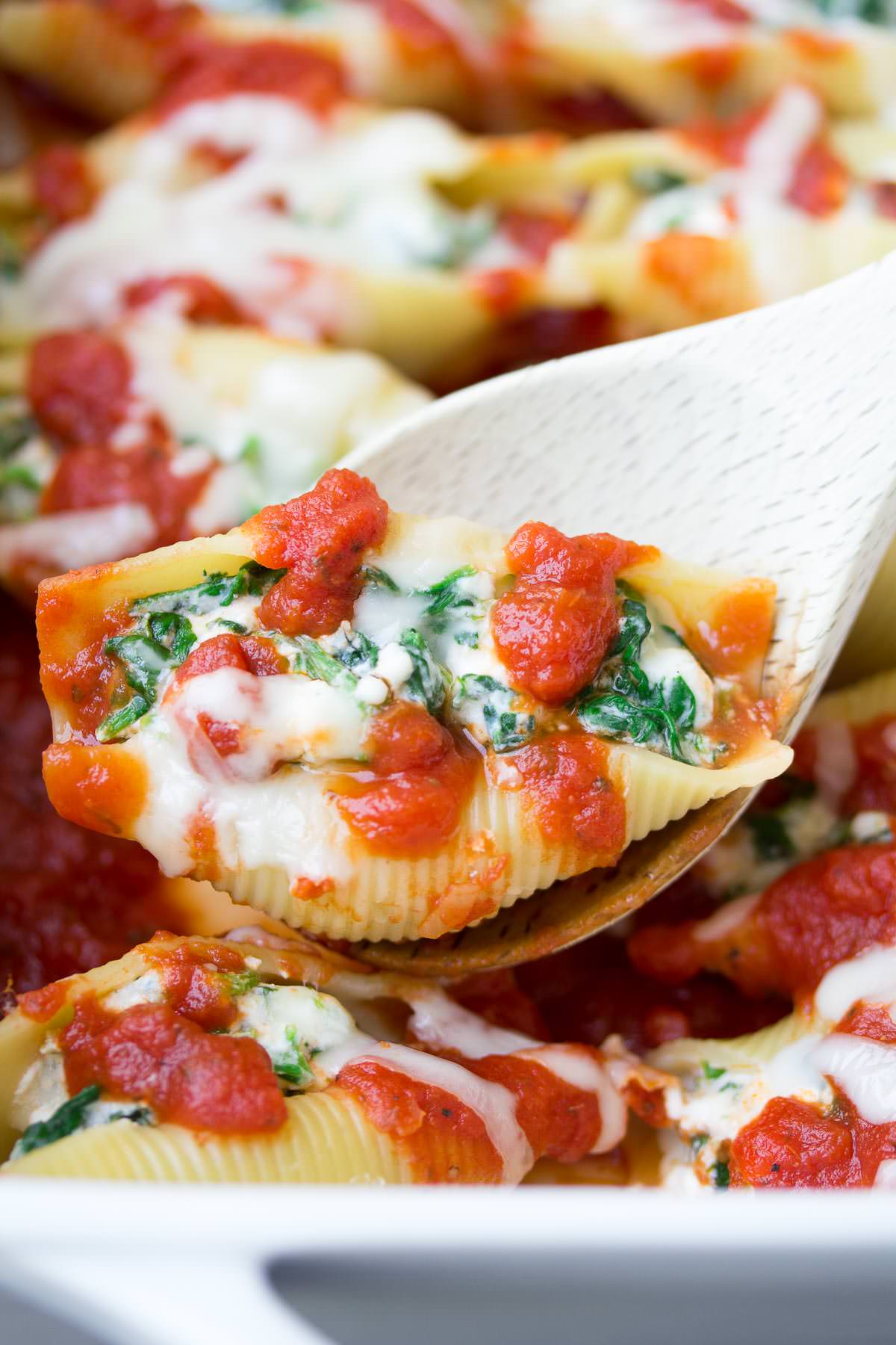 This easy Spinach and Cheese Stuffed Shells recipe is one of our favorite dinners! These pasta shells are lightened up with a secret ingredient, make ahead, and freezer friendly!