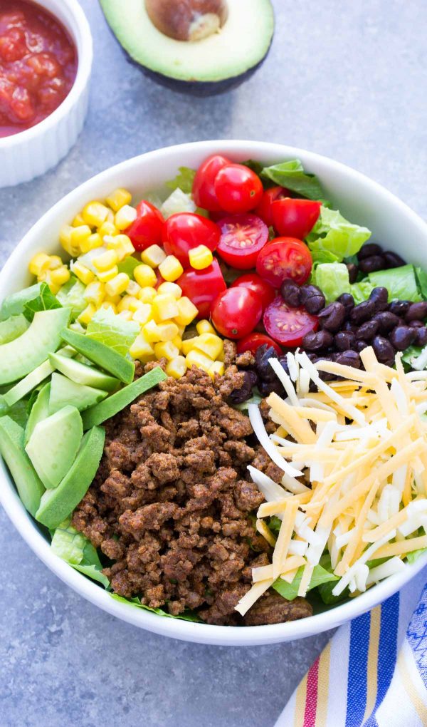 Wondering what to make for dinner? This 20 Minute Healthy Taco Salad recipe will make the whole family happy! It has taco beef, cheese, avocado and salsa dressing! | www.kristineskitchenblog.com