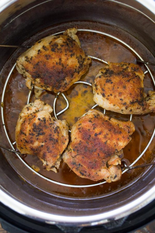 Easy Instant Pot Chicken Thighs with the best seasoning! How to cook perfectly moist and juicy chicken thighs in your Instant Pot pressure cooker. From fresh or frozen. Use boneless, skinless thighs or bone in. One of our favorite healthy chicken recipes! Chicken thighs on a trivet in an Instant Pot.