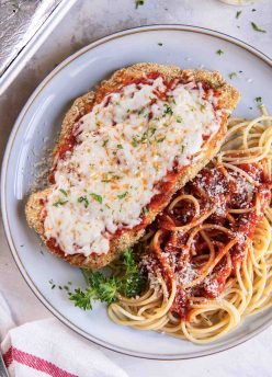 Chicken parmesan served with spaghetti.