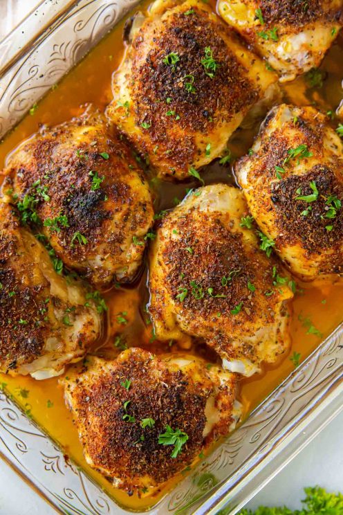 Baked chicken thighs in baking dish.