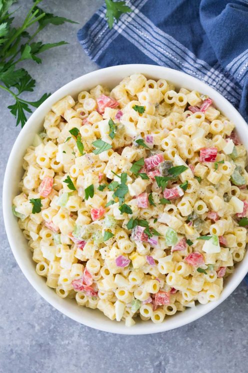 Macaroni salad with egg in a white bowl.