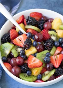 Fresh fruit salad in a bowl with a spoon.