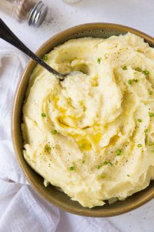 Mashed potatoes in a bowl with a serving spoon.