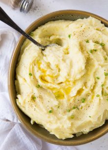 Mashed potatoes in a bowl with a serving spoon.