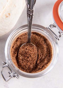 Homemade taco seasoning in a small jar with a spoon.