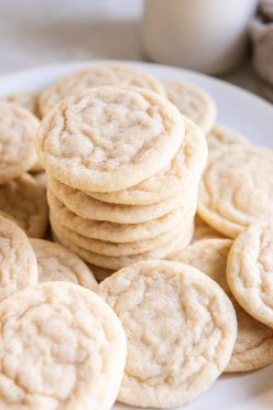 Sugar cookies stacked on top of each other with more cookies around them.