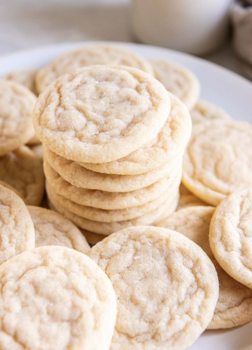 Sugar cookies stacked on top of each other with more cookies around them.
