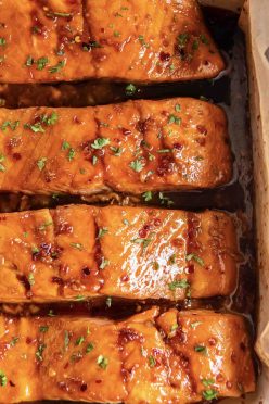 Four honey glazed baked salmon fillets in baking dish.