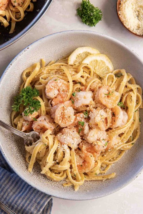 Shrimp pasta served in a shallow bowl with a fork.