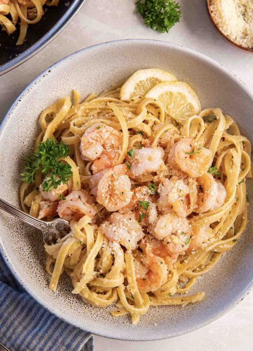 Shrimp pasta served in a shallow bowl with a fork.