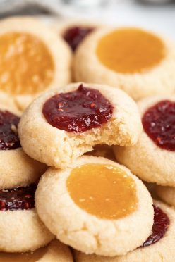 Close up of stacked thumbprint cookies with a bite taken out of one.