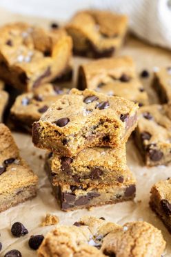 Three cookie bars stacked on top of each other with a bite taken out of the top bar.
