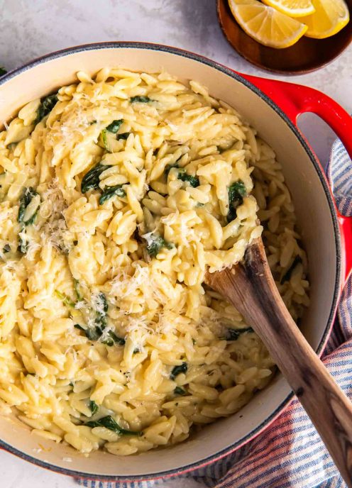 Lemon garlic parmesan orzo in a Dutch oven pot with a wooden spoon.
